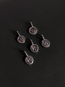 A collection of 'YIN YANG' silver charms from the brand Kathrin Jona, each showcasing varying diameters.