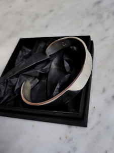 A Heavy Silver Cuff by Kathrin Jona in a black box.