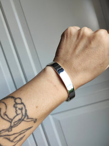 A woman wearing a Kathrin Jona Heavy Silver Cuff bracelet with a tattoo on it.