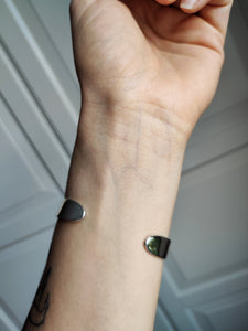 A woman's wrist with two Kathrin Jona Heavy Silver Cuff bracelets on it.