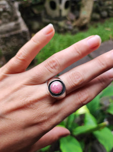 A woman's hand holding a Rhodochrosite Silver Signet Ring by Kathrin Jona.