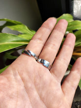 Load image into Gallery viewer, A hand holding two Kathrin Jona Mother of Pearl Ring adjustable rings in front of a plant.
