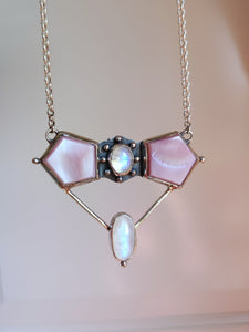A Kathrin Jona Mother of Pearl Statement Necklace with a pink and white stone on it.