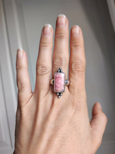 A woman's hand holding a Kathrin Jona Rhodochrosite Statement Ring.