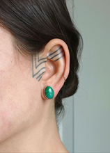 Load image into Gallery viewer, A close-up of a person&#39;s ear featuring a geometric tattoo pattern behind it, adorned with the large, oval Oval Turquoise Studs by Kathrin Jona, crafted from recycled silver.
