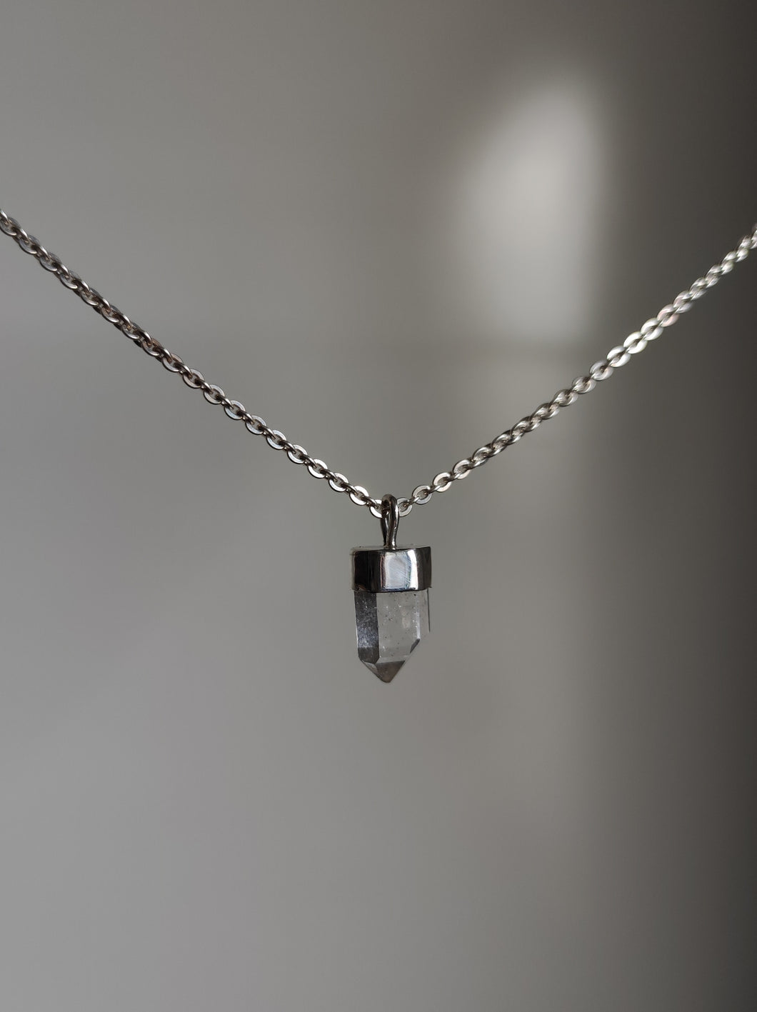 A Australian Clear Quartz Necklace by Kathrin Jona with a small crystal on it.