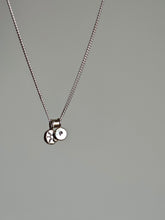 Load image into Gallery viewer, Silver necklace with a matching chain, featuring the &#39;SUN&#39; silver charm by Kathrin Jona, which includes two round pendants: one adorned with a star and the other with a lowercase &quot;p,&quot; set against a plain background.
