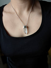 Load image into Gallery viewer, A person wearing a black shirt accessorized with the Australian Clear Quartz Necklace #2 by Kathrin Jona, featuring a clear crystal pendant crafted from recycled silver.
