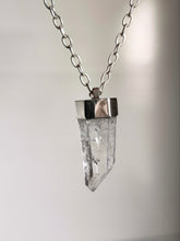 Load image into Gallery viewer, The Australian Clear Quartz Necklace #1 by Kathrin Jona features a stunning clear quartz crystal pendant with a silver cap, elegantly hanging from an Australian silver chain, set against a neutral background.
