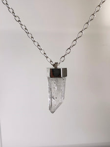 The Australian Clear Quartz Necklace #1 by Kathrin Jona gracefully hangs from a silver chain against a simple white backdrop.