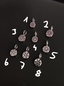 A group of Kathrin Jona sterling silver 'SUN' charms with numbers.