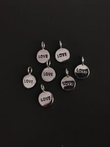 Five Kathrin Jona 'LOVE' charms with love and love engraved on them, each featuring a loop for easy attachment.