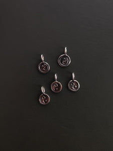 A collection of Kathrin Jona sterling silver 'YIN YANG' charm pendants with varying diameters.