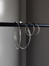 Load image into Gallery viewer, A pair of Kathrin Jona thin hoop earrings hanging on a rod.

