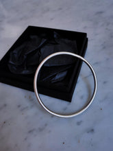 Load image into Gallery viewer, Hand forged Kathrin Jona round silver bangle in a black box.
