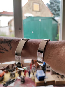 A pair of Kathrin Jona Heavy Silver Cuff bracelets on a person's arm.