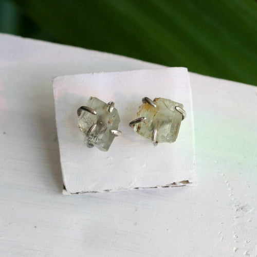 A pair of Kathrin Jona Raw Aquamarine Earring Studs with a piece of quartz on top.