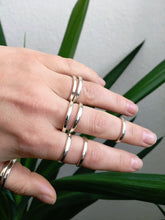 Load image into Gallery viewer, A woman&#39;s hand holding a pair of Kathrin Jona Stacker rings with rounded edges.
