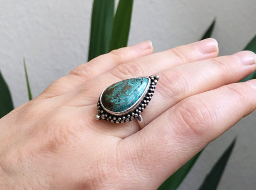 A woman's hand holding a *Magic* Ring Turquoise by Kathrin Jona.
