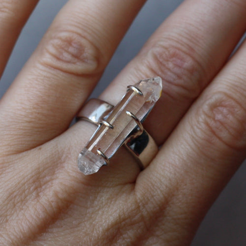 A person wearing a Kathrin Jona Clear Quartz Double Point Ring.