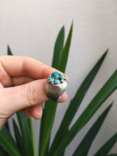 Load image into Gallery viewer, A hand holding a Turquoise Cluster Signet Ring by Kathrin Jona.
