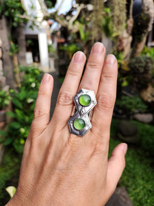 A woman's hand holding a Green Shield Jadeite Ring #2 by Kathrin Jona with a green stone.