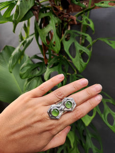A hand holding a Kathrin Jona Green Shield Jadeite Ring #2 with a green stone.