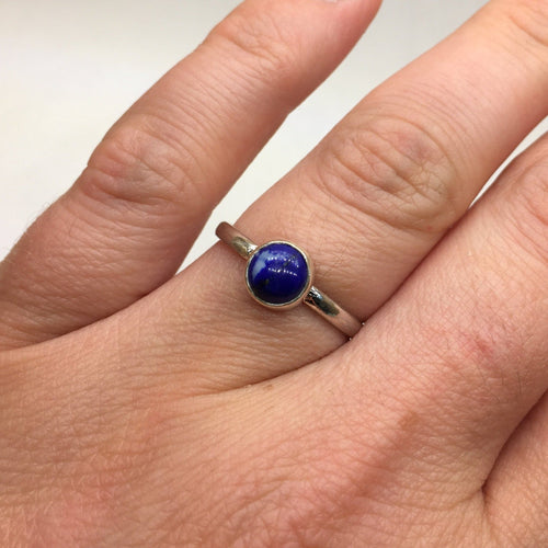 A woman's hand holding a Kathrin Jona Lapis Lazuli Stacker ring.