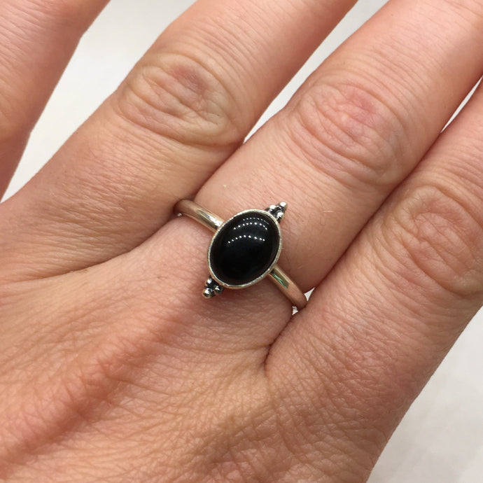A woman's hand holding a Kathrin Jona Oval Onyx Ring.