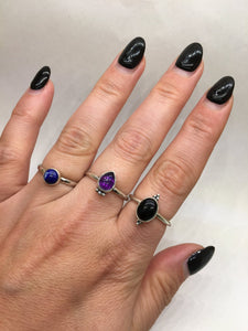 A woman's hand with black nails and a Kathrin Jona Amethyst drop stacker ring.