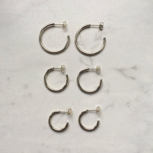 A set of Kathrin Jona silver hoop earrings – different sizes – on a marble surface.