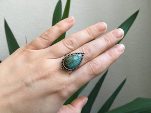 A woman's hand holding a Kathrin Jona Magic Ring Turquoise.