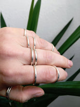Load image into Gallery viewer, A woman&#39;s hand holding a stack of Kathrin Jona round Stacker rings.

