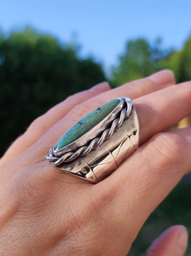 A woman's hand holding a Kathrin Jona Turquoise Shield Ring.