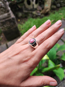 A woman's hand holding a Rhodochrosite Silver Signet Ring from Kathrin Jona.
