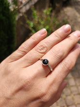 Load image into Gallery viewer, A woman&#39;s hand holding a Round Obsidan Silver Stacker Ring by Kathrin Jona.
