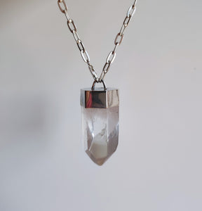 A Clear Quartz Point Statement Necklace from Kathrin Jona with a clear quartz crystal on it.