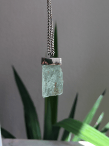 An Aquamarine Necklace No.4 hanging from a silver chain, made by Kathrin Jona.