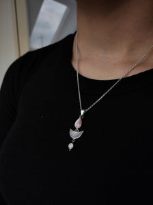 A woman is wearing a Kathrin Jona necklace with a Mother of Pearl Moonstone pendant.