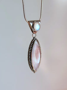 A Mother of Pearl Granulation Necklace with a white stone and a silver chain, made by Kathrin Jona.