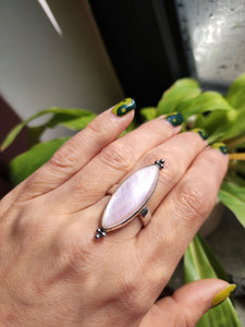 A hand holding a Kathrin Jona Mother of Pearl Ring adjustable.