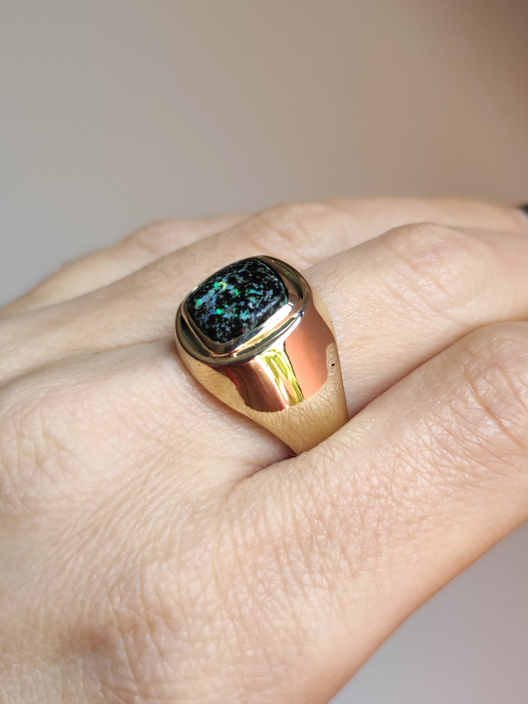 A woman's hand holding a Kathrin Jona Leopard Opal 9k Gold Signet Ring.