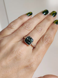 A woman wearing a Leopard Opal Silver Ring M by Kathrin Jona with a green stone.