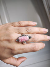 Load image into Gallery viewer, A woman&#39;s hand is holding a Kathrin Jona Rhodochrosite Statement Ring.
