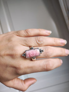 A woman's hand is holding a Kathrin Jona Rhodochrosite Statement Ring.